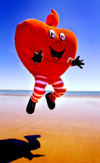 Springend verkleed lachebekje aan het strand
